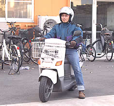 バイクに乗って弁当を運ぶ下村さん バイクに乗って弁当を運ぶ下村さん